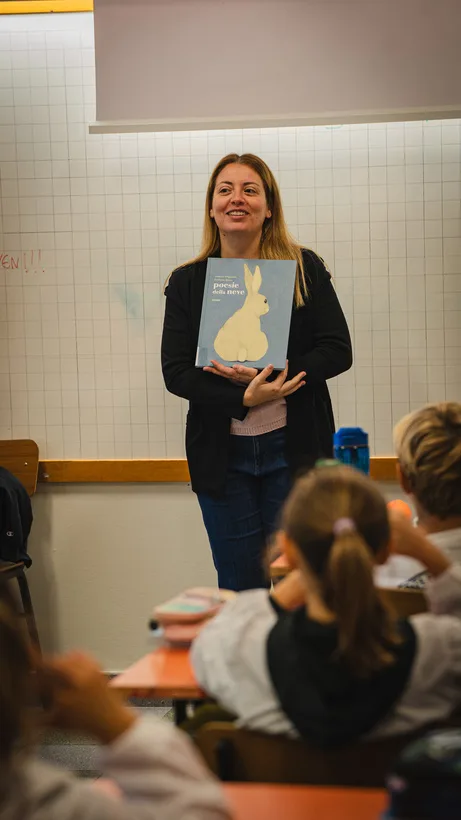 Un’insegnante mostra un libro illustrato con un coniglio