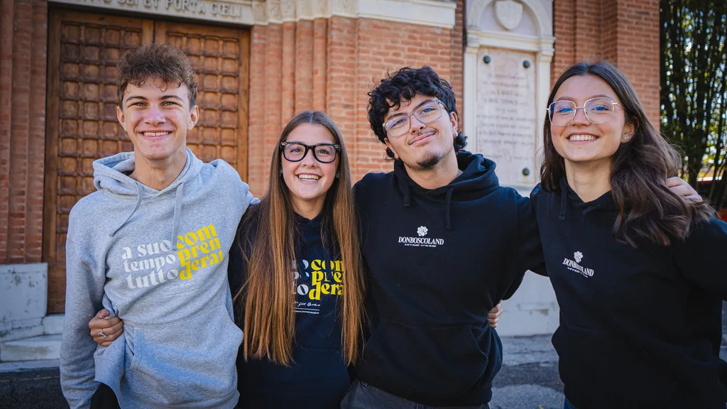 Quattro animatori sorridenti con le felpe del Centro Giovanile