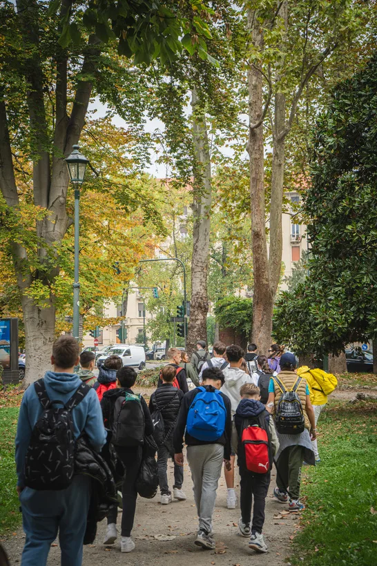 Una classe in cammino lungo un viale alberato