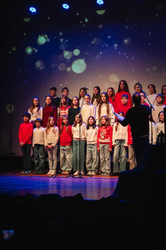 Il coro e il gruppo di teatro sul palco durante lo spettacolo di Natale