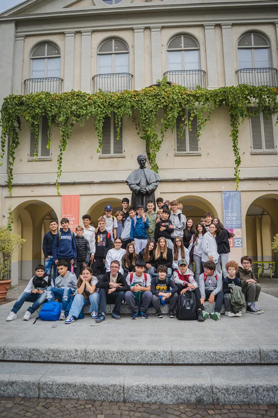 Una classe in posa davanti alla statua di Don Bosco